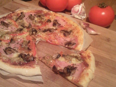 Pizza z szynka ,pieczarkami i oliwkami .