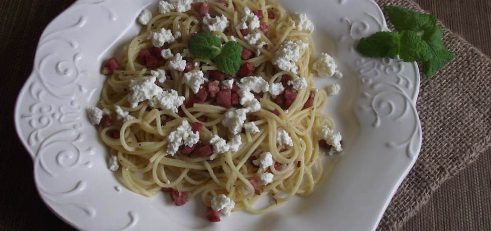 Spaghetti z kiełbasą smażoną z cebulą podane z białym serem ...