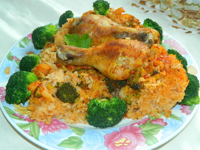 Pałki kurczaka pieczone na ryżu z warzywami.
