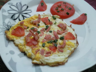 Kolorowy omlet jajeczny z szynką, pomidorem i szczypiorem ...
